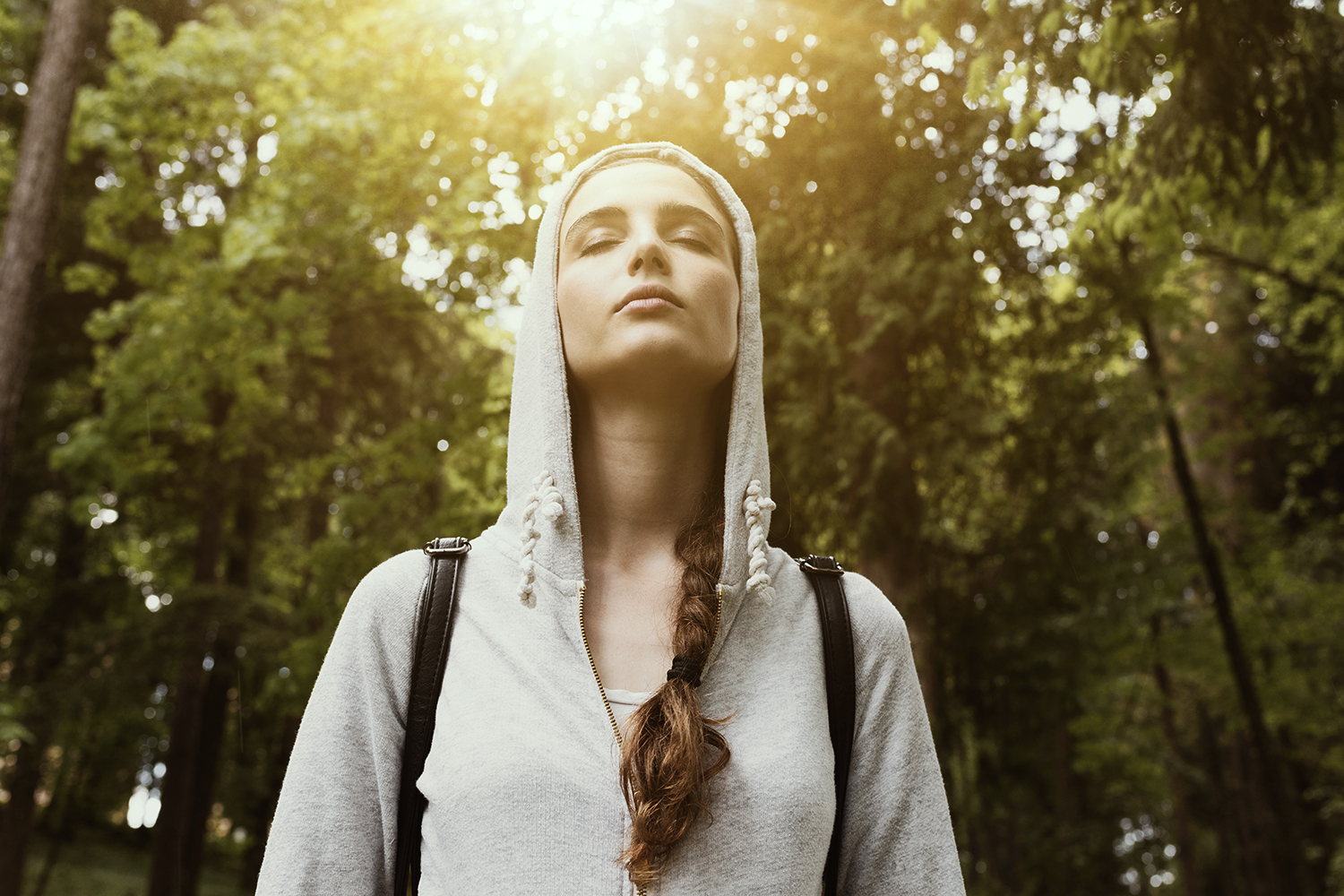 a young woman stopping to take a peaceful moment to breathe deeply