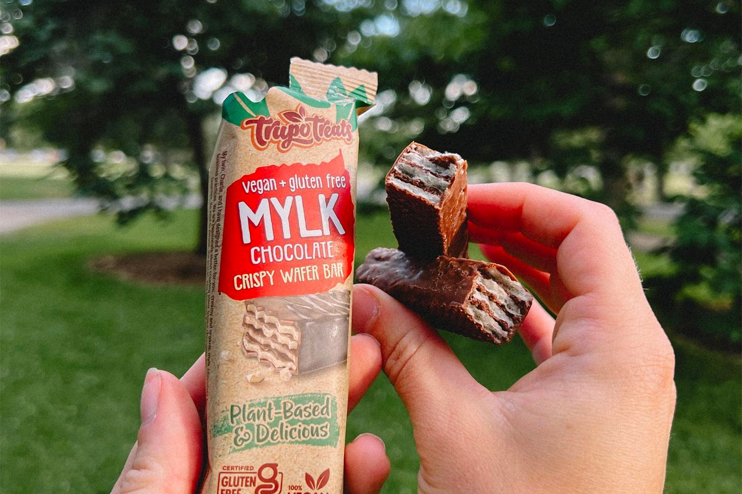 a woman breaking open some crispy chocolate wafer bars