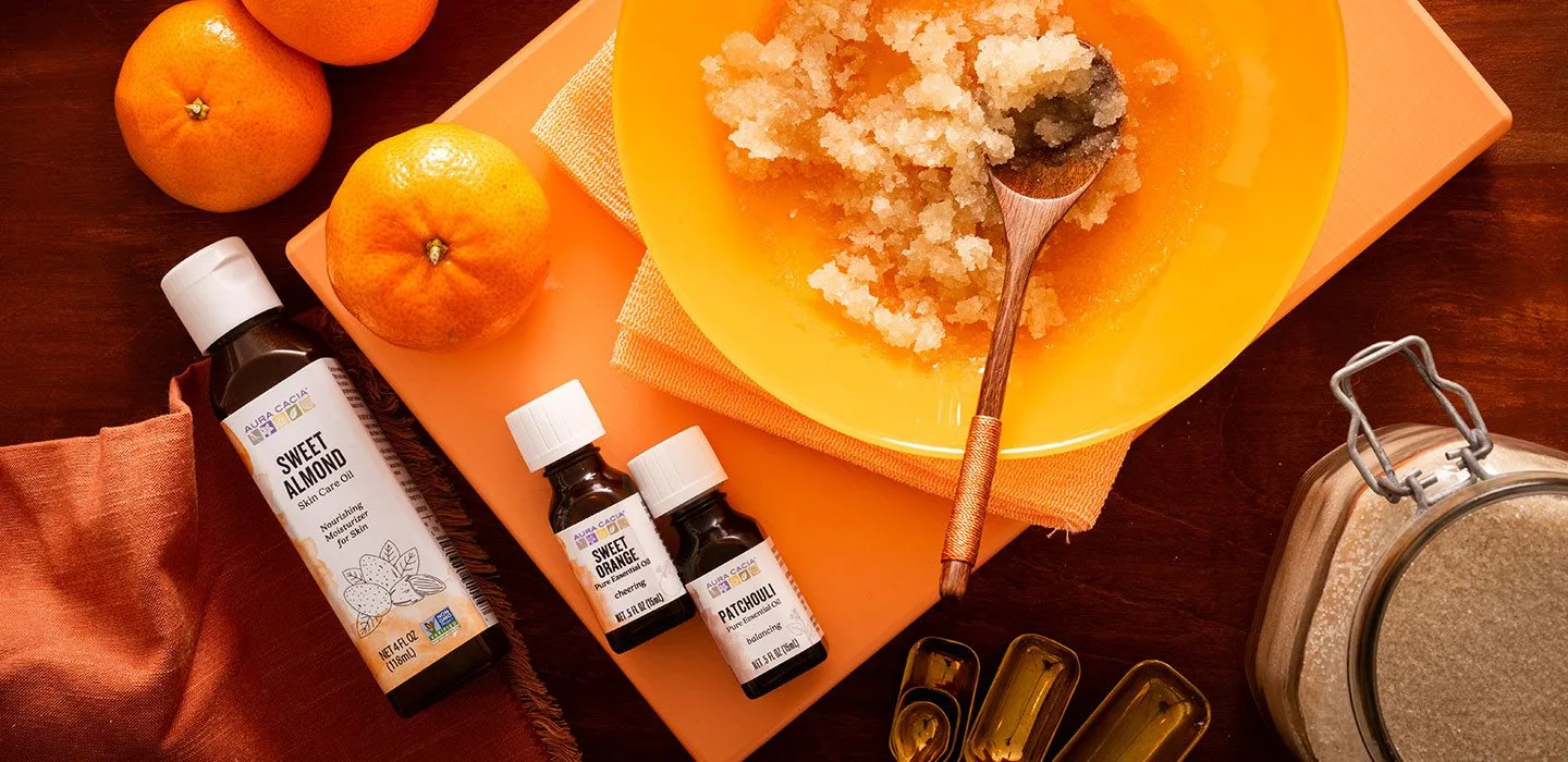 Bottles of essential oils with bowl granulated sugar