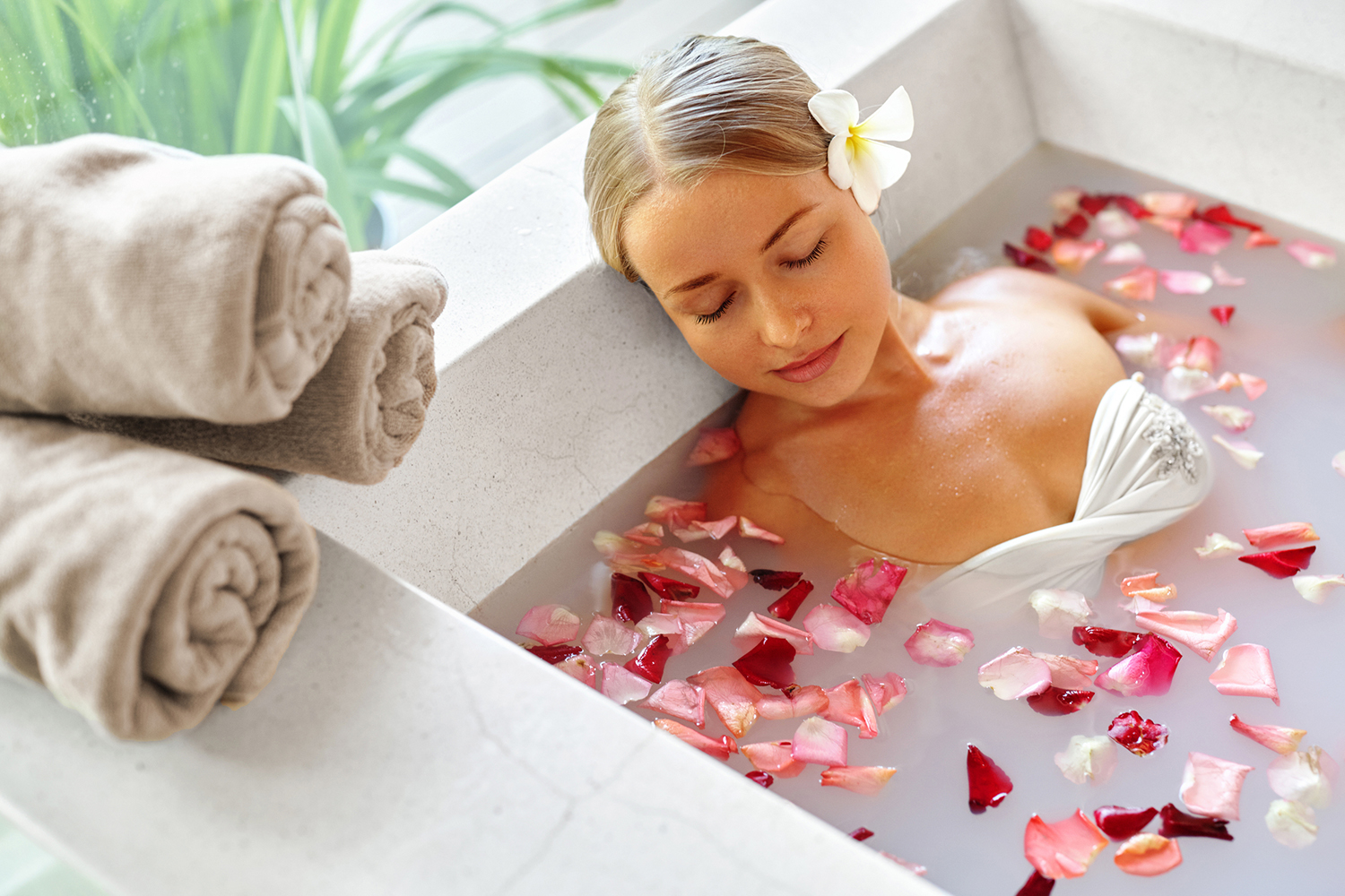a woman taking a calming bath with milk and herbs