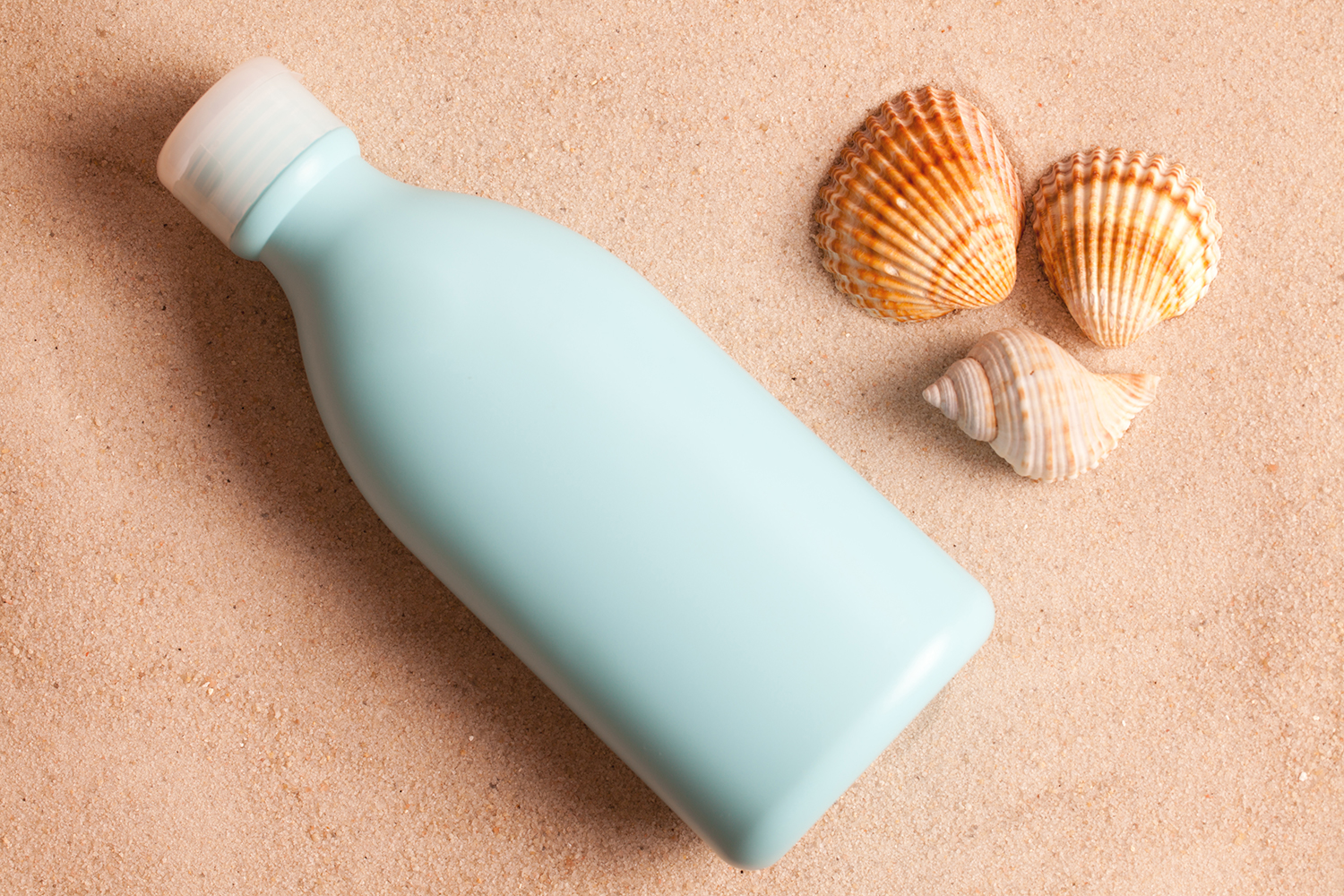 A bottle of sunscreen in the sand