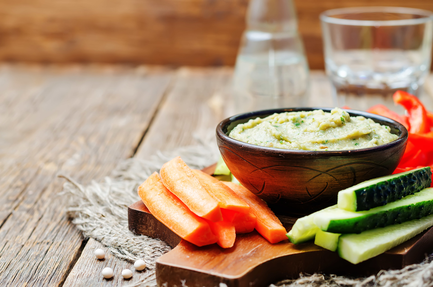 Lite Miso Dip in a wooden bowl surrounded by vegetable sticks with a rustic background.