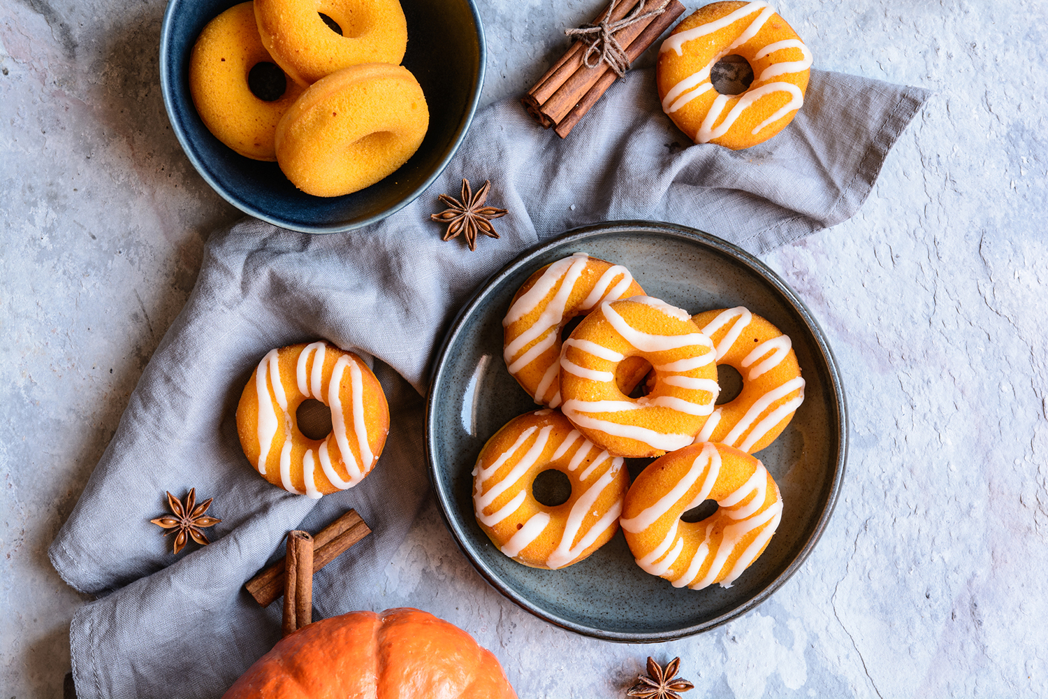 plates of pumpkin donuts decorated differently