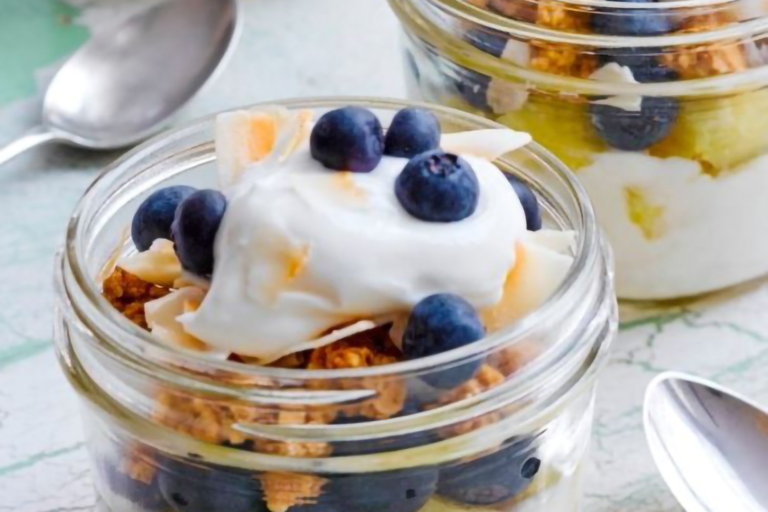 blueberries, pineapple, granola, and yogurt served in small jars