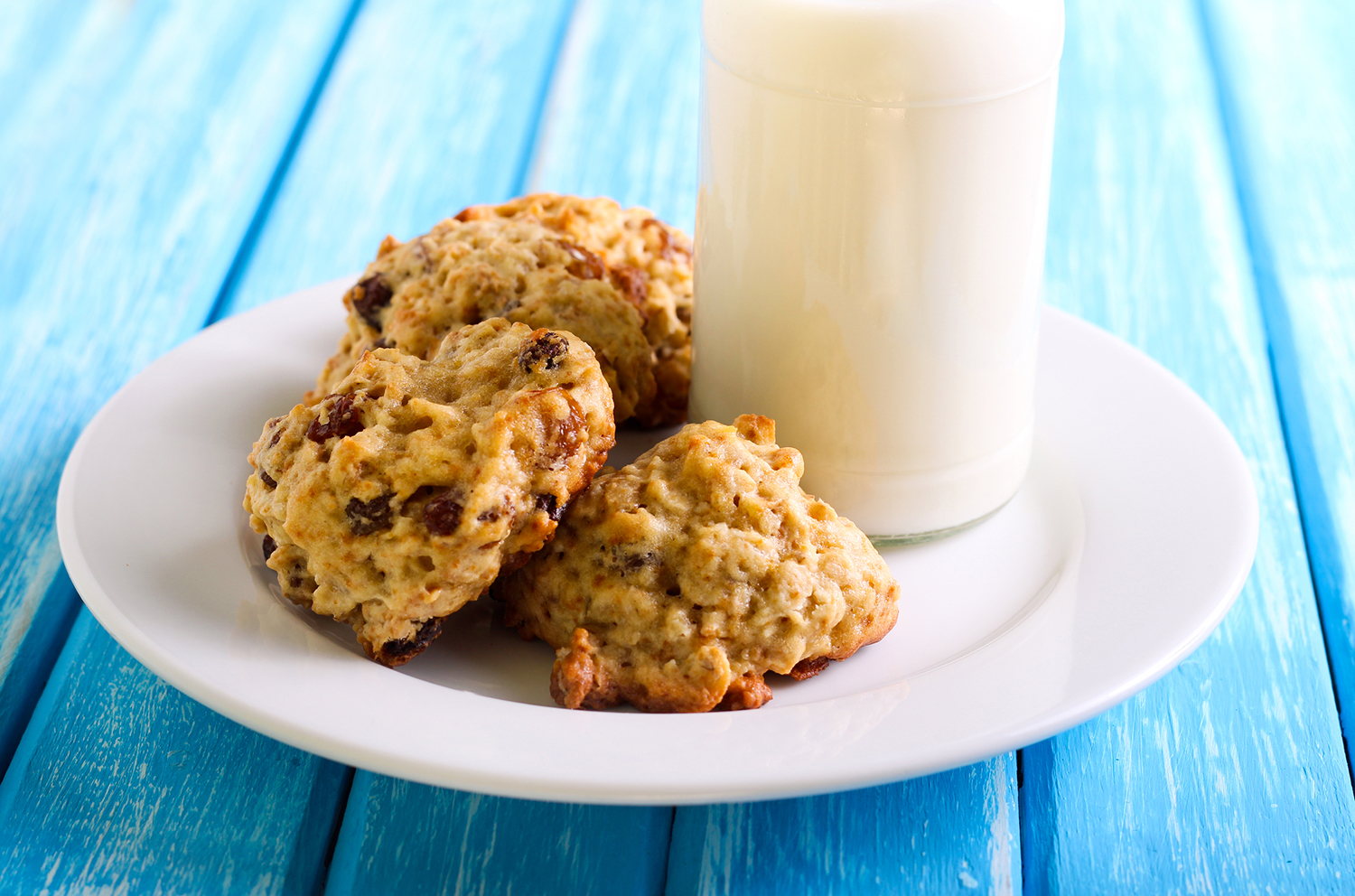 Applesauce raisin cookies on a plate with milk