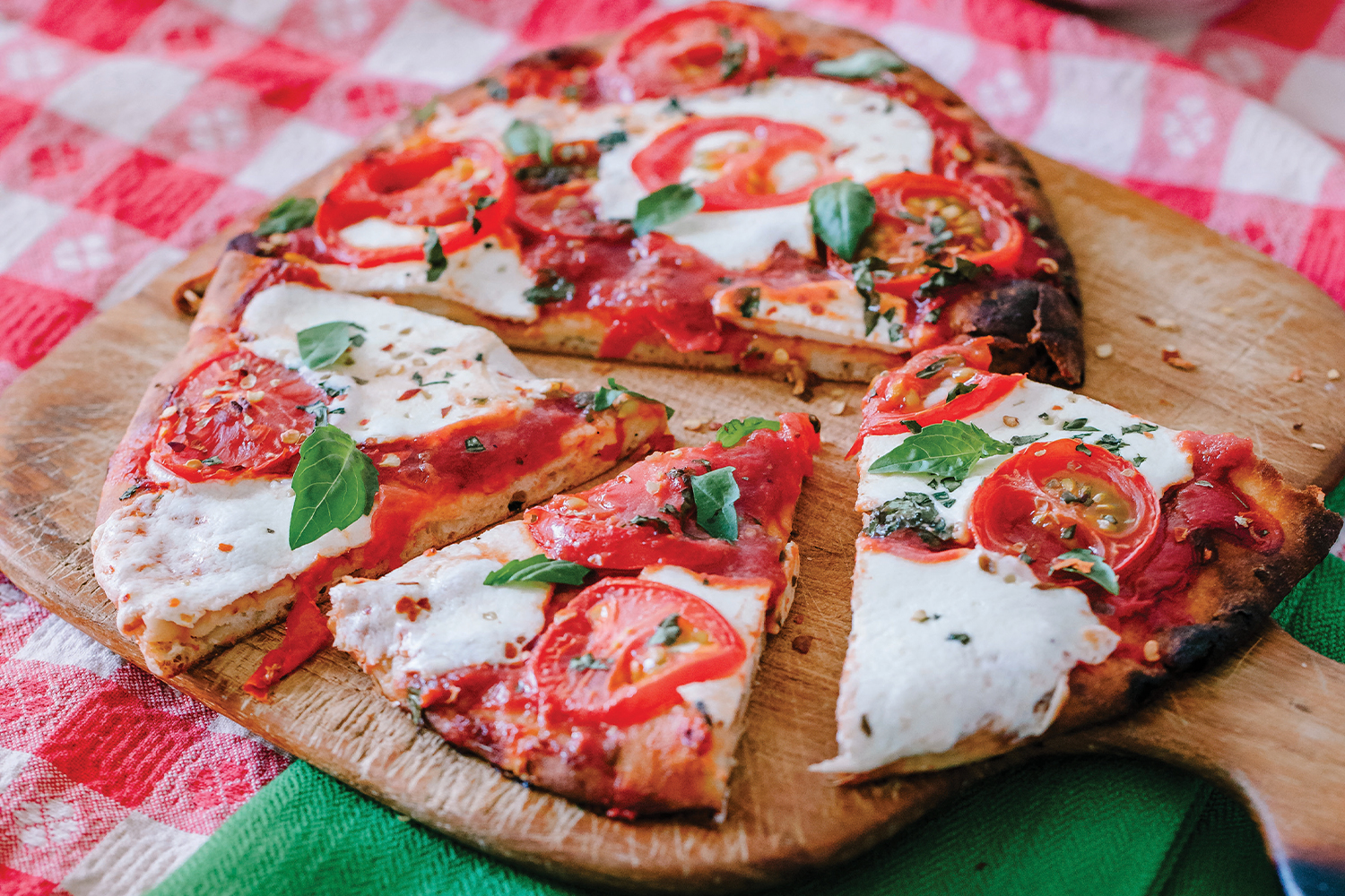 Margherita Flatbread Pizza on a wooden pizza board, cut and ready to serve.