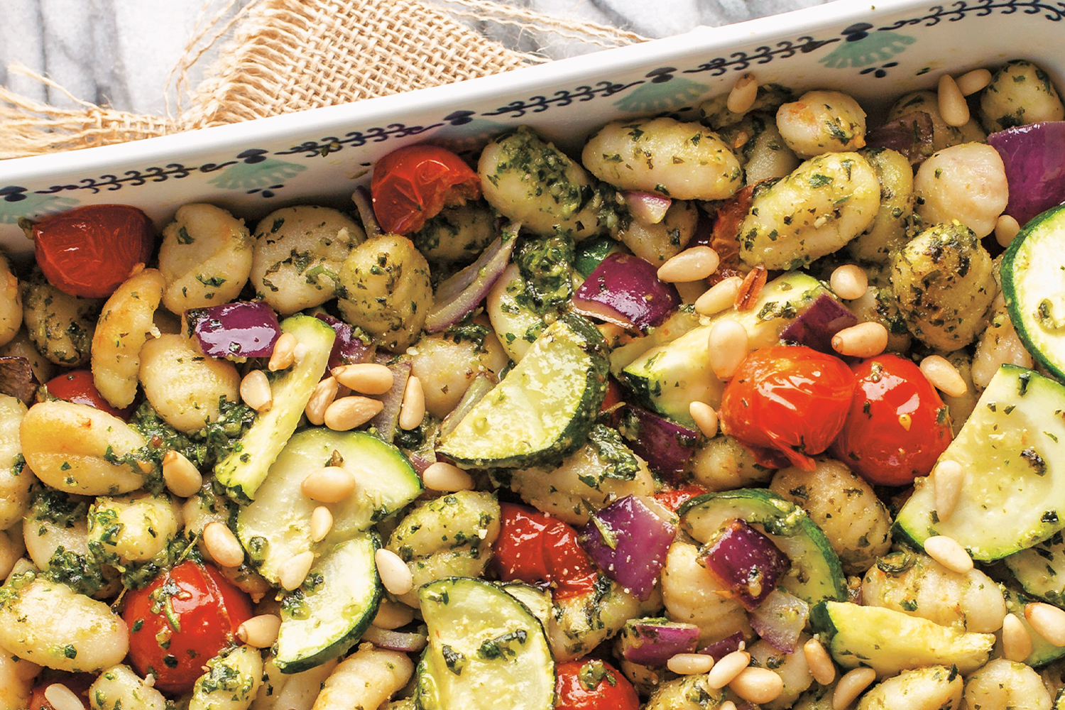gnocchi and veggies with pesto in a pan