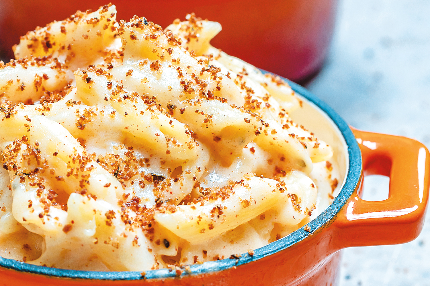 Smoky mac and cheese served in an orange mini dutch oven.