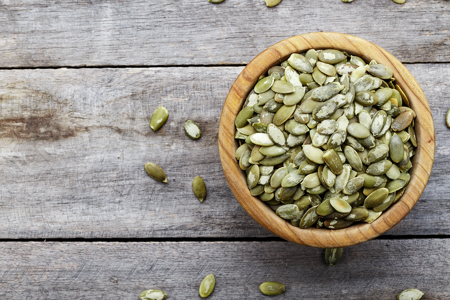 a bowl of peeled pumpkin seeds, ready for roasting