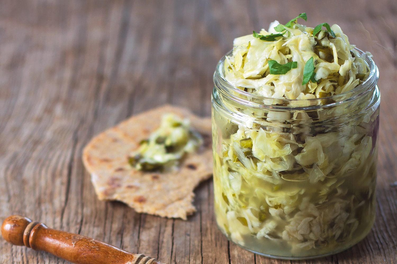 A jar of taco kraut with a piece of flatbread