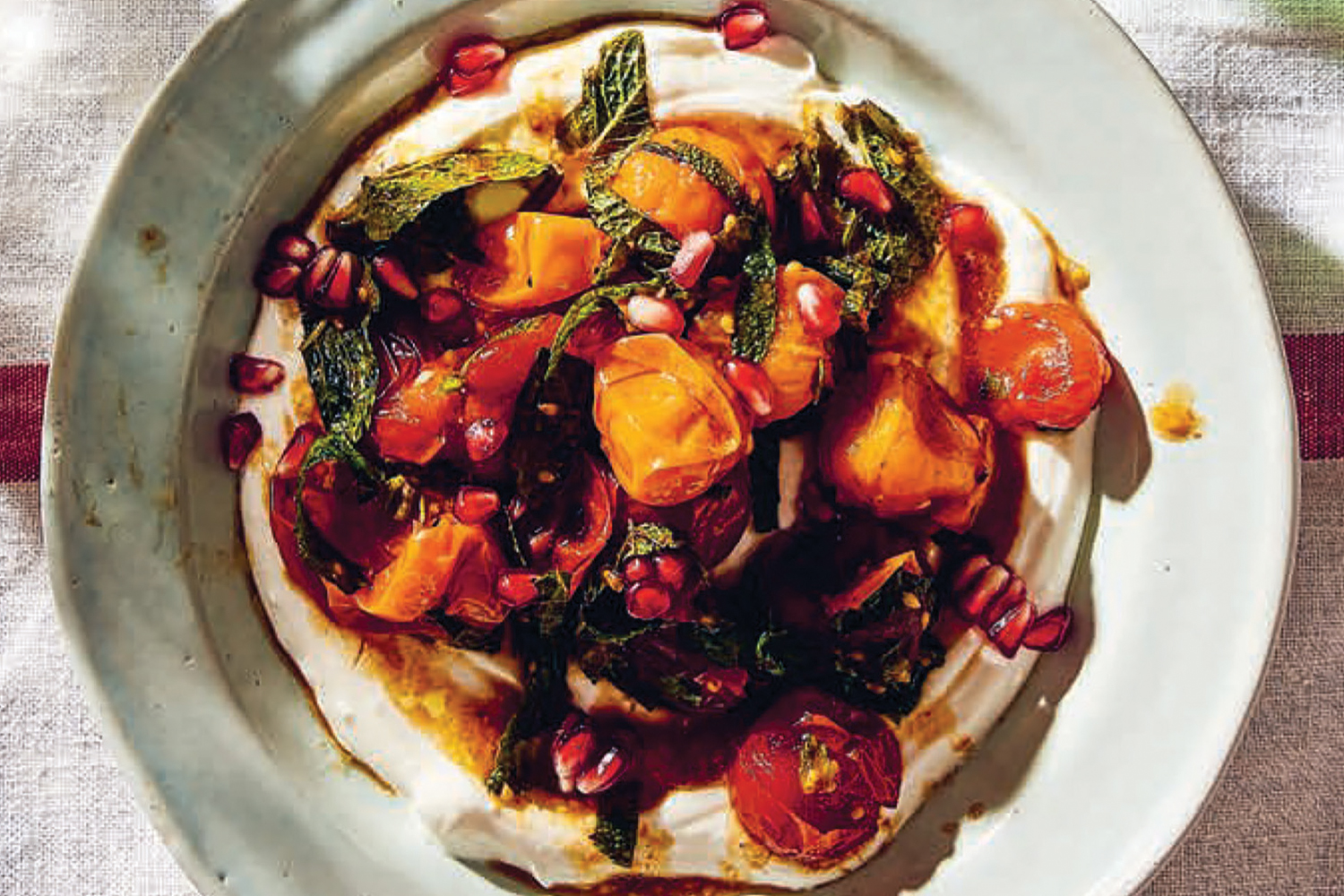 a plate of grilled tomatoes on a bed of yogurt