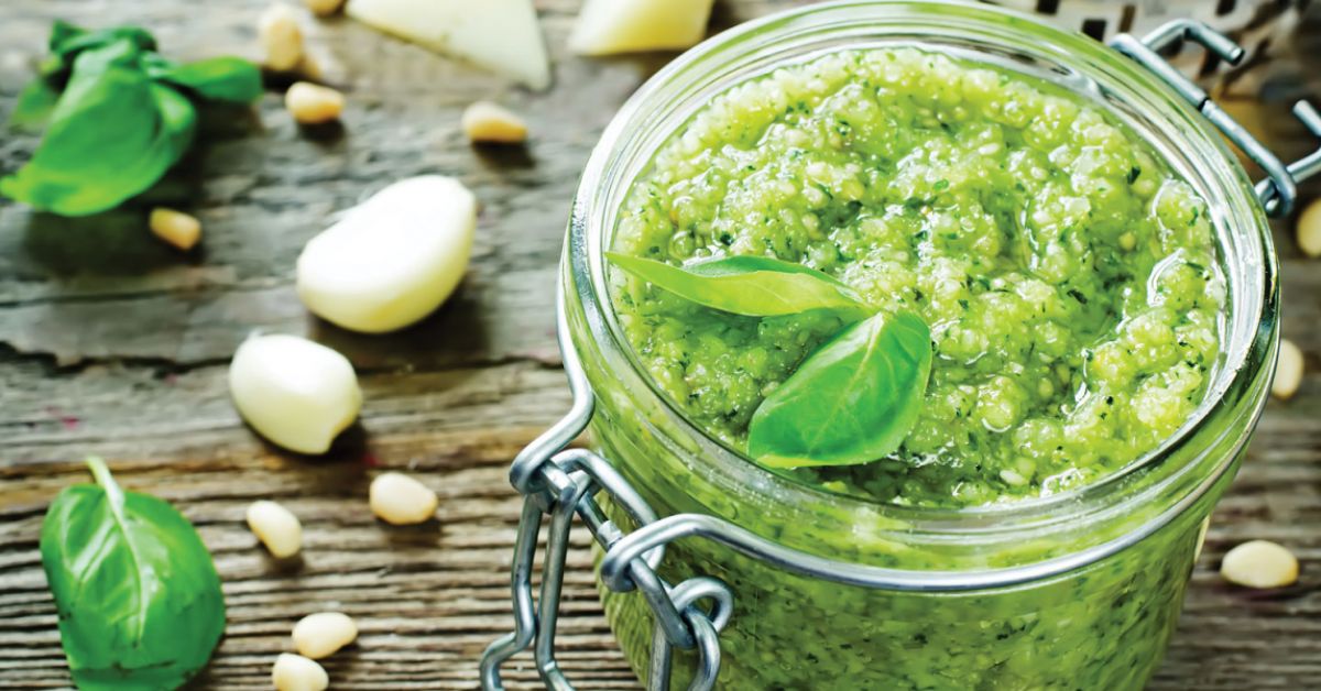 A canning jar of fresh basil pesto with garlic and cheese