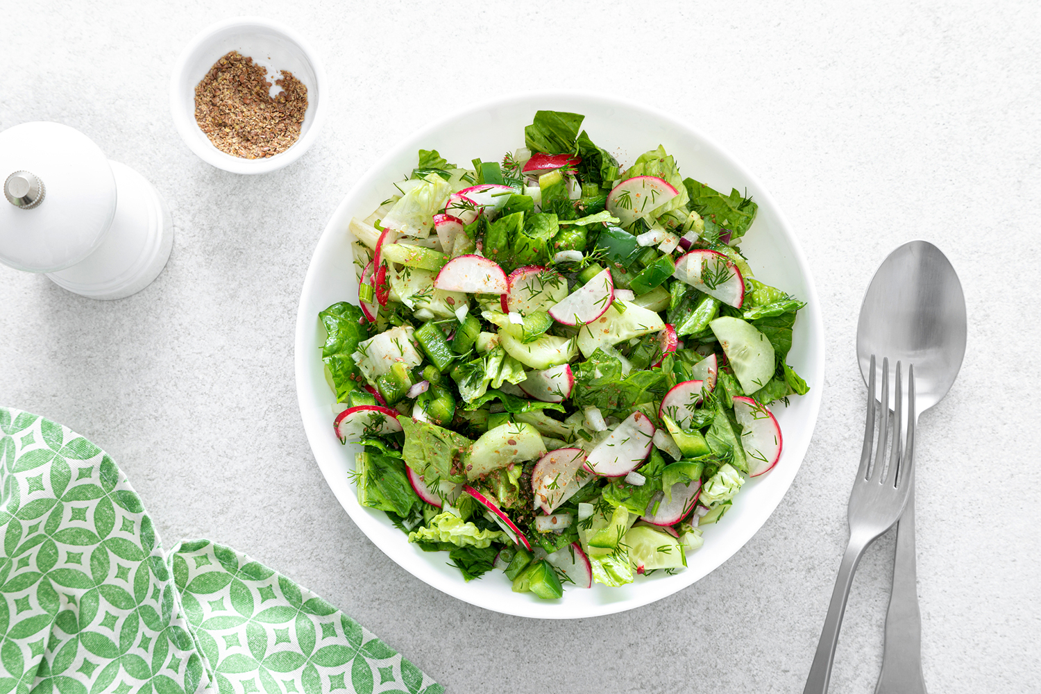 a bowl of green salad with radishes