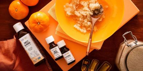 Bottles of essential oils with bowl granulated sugar