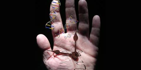 a senior's hand with a clock, puzzle pieces, and strands of DNA