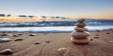 Stones balanced on a beach at sunrise