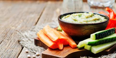 Lite Miso Dip in a wooden bowl surrounded by vegetable sticks with a rustic background.