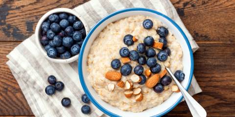 a bowl of coconut porridge with almonds and blueberries