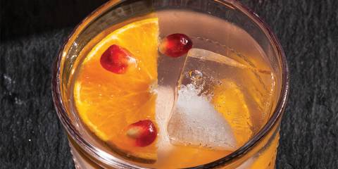 a glass of citrus and pomegranate mocktail