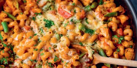 a skillet filled with pasta and chicken