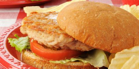 a ground chicken pattie on a bun with lettuce and tomato