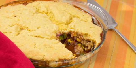 a pie dish of beans topped with a cornbread crust