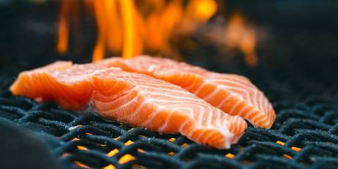 gorgeous salmon on a flaming charcoal grill