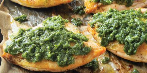 Pistachio Pesto Chicken on a baking sheet with parchment paper.
