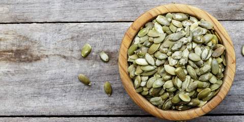 a bowl of peeled pumpkin seeds, ready for roasting
