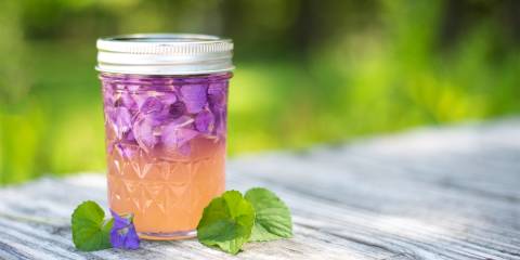 a jar of violet petals soaking into vinegar