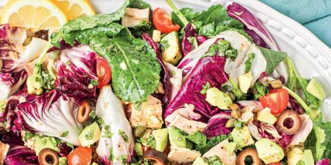 a plate of kale salad with tuna and citrus-basil dressing