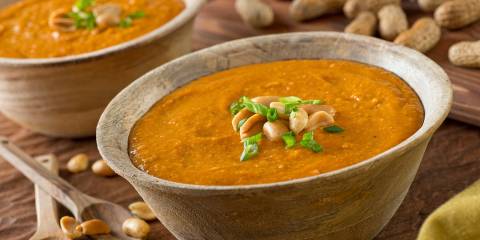 a bowl of peanut soup with garnish
