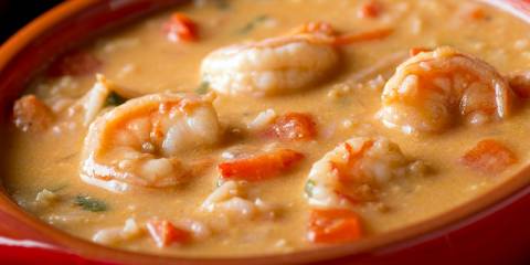 a bowl of creamy coconut soup with shrimp and spices