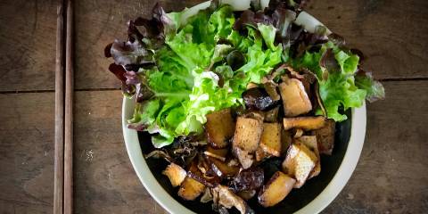 a bowl of stir-fried mushrooms and tofu, garnished