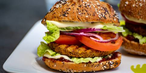 a plate with two stacked burgers with vegetarian patties
