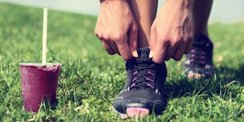 an athlete tying their shoes before running, with a beetroot smoothie