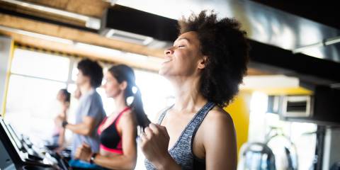 Happy group of fit people training in gym.