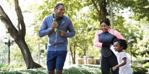 Family enjoying outdoor activity and jogging through a park.