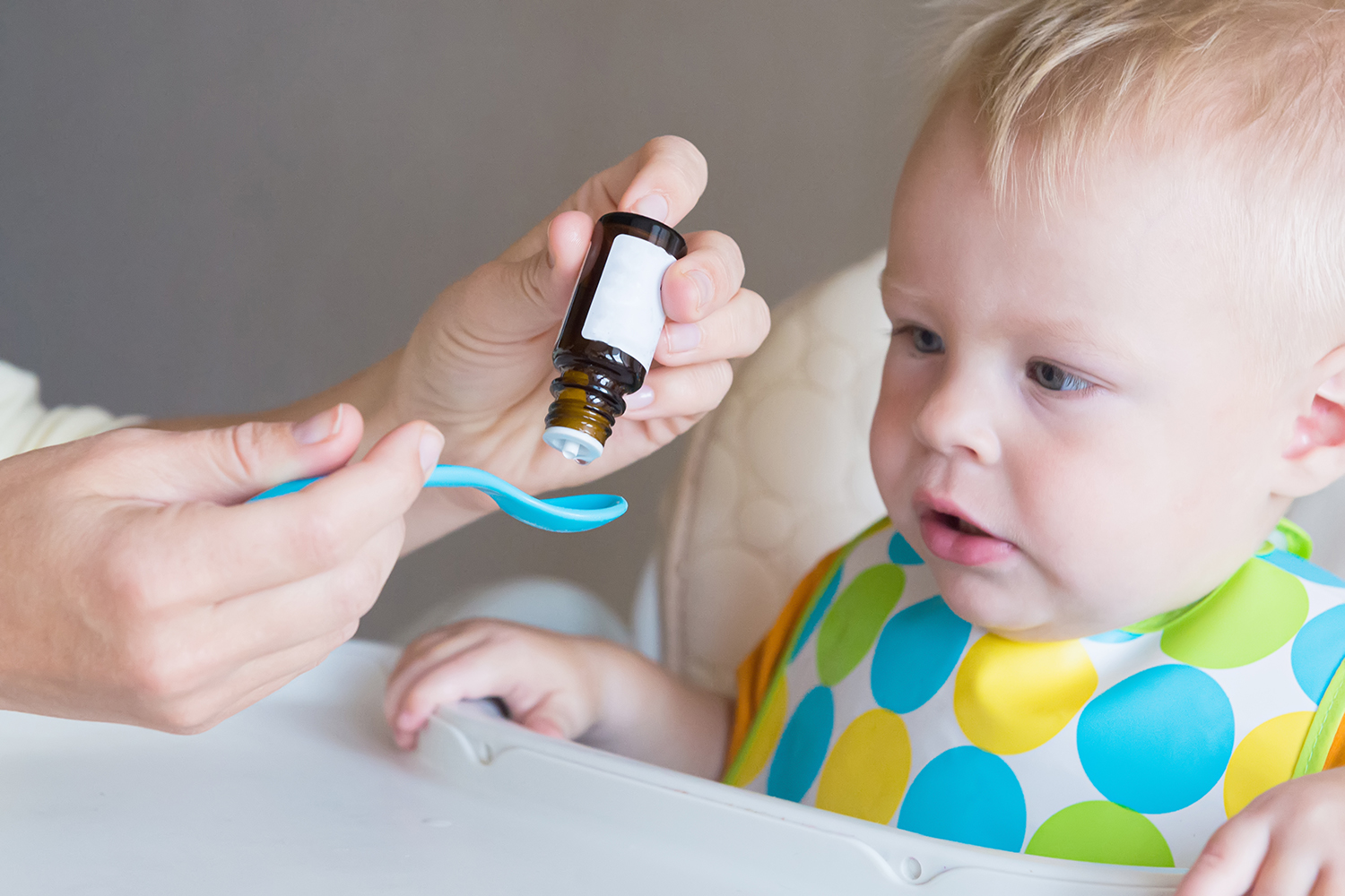 a mother giving a liquid supplement to her baby